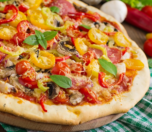 Pizza mit salami, tomate, käse und pilzen | Kostenlose Foto