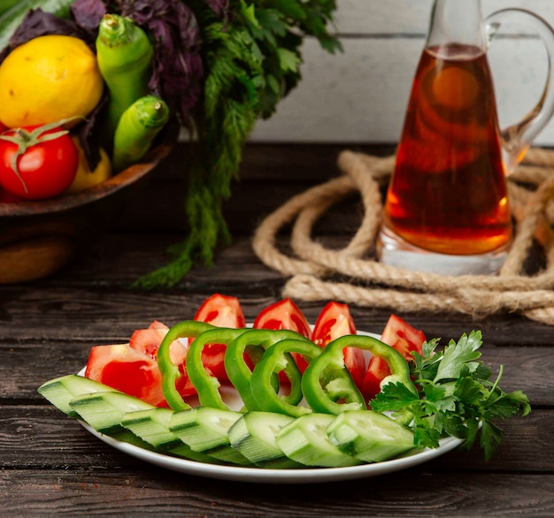 Platte mit gehackten tomaten und gurken und paprika auf dem tisch ...