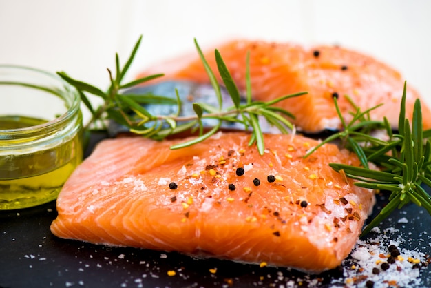 Portionen frische rohe lachsfilets mit aromatischen kräutern und olivenöl Premium Fotos