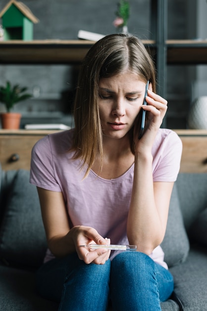 Portrat Einer Frau Mit Thermometer Am Handy Sprechen Kostenlose Foto