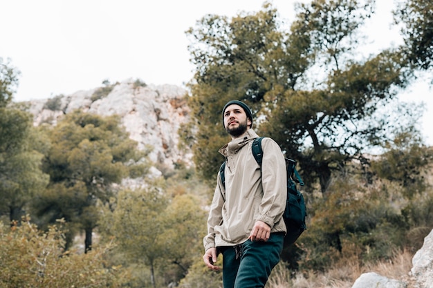 Porträt eines männlichen wanderers mit seinem rucksack, der in den bergen wandert Kostenlose Fotos