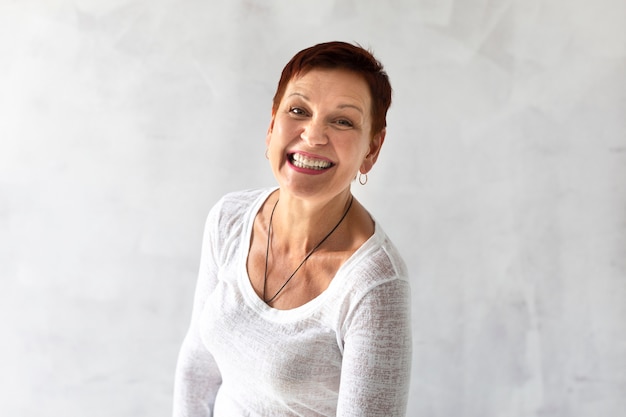 Reife frau mit dem lächeln des kurzen haares Kostenlose Foto