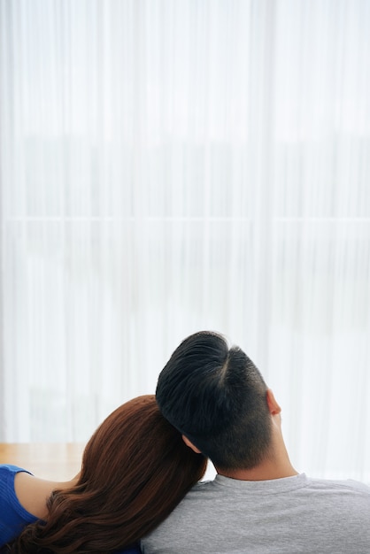 Romantische paare, die zusammen zu hause auf couch vor