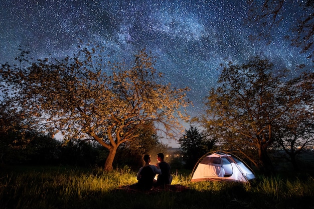 Romantische Paartouristen Die Am Lagerfeuer Nahe Zelt Unter Bäumen Und Schönem Nachthimmel 