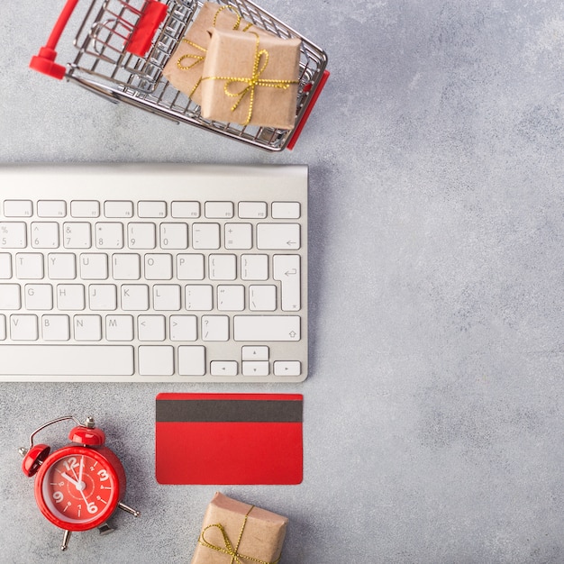 Rote kreditkarte, tastatur und weihnachtsgeschenke auf grauer tabellenebenenlage, kopienraum. Premium Fotos