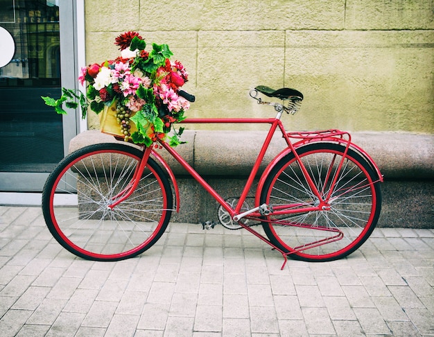 Rotes vintage fahrrad mit blumenkorb PremiumFoto