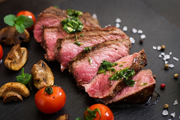 Saftiges steak mittleres seltenes rindfleisch mit gewürzen und ...