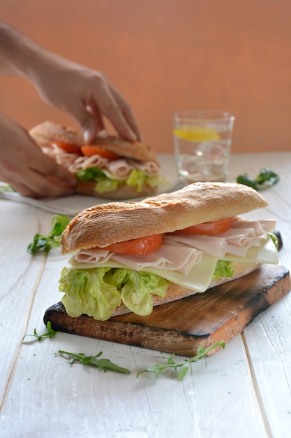 Sandwich mit käse und putenschinken serviert mit salat und tomaten ...