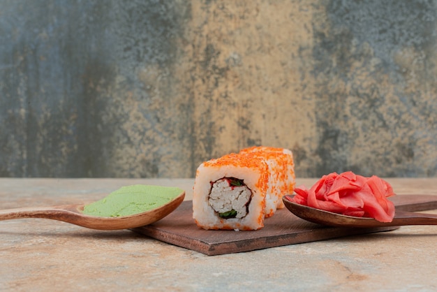 Satz köstliche sushi-rolle mit löffel und sojasauce auf marmor ...