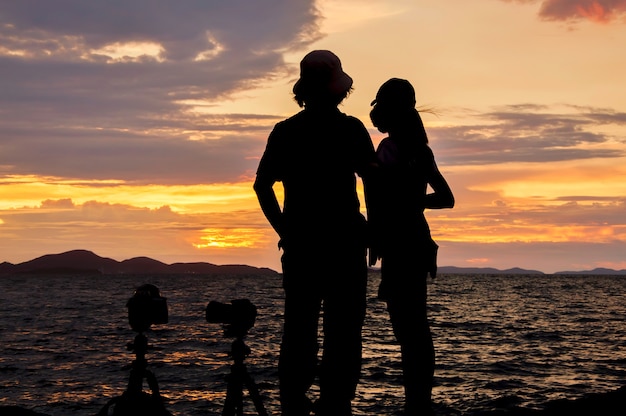 Schattenbild Von Den Paaren Die Auf Dem Strand Bei Sonnenuntergang Stehen Premium Foto 