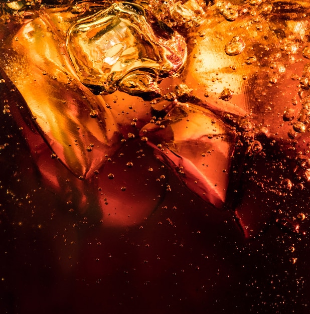 Schliessen Sie Herauf Ansicht Der Eiswurfel Im Dunklen Cola Hintergrund Textur Des Kuhlenden Sussen Sommergetranks Mit Schaum Und Makroblasen An Der Glaswand Zischen Oder Schweben Bis Zur Oberflache Kostenlose Foto