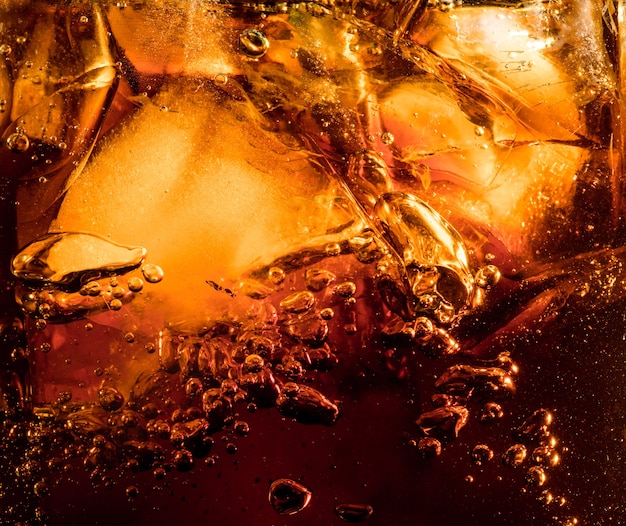 Schliessen Sie Herauf Ansicht Der Eiswurfel Im Dunklen Cola Hintergrund Textur Des Kuhlenden Sussen Sommergetranks Mit Schaum Und Makroblasen An Der Glaswand Zischen Oder Schweben Bis Zur Oberflache Kostenlose Foto