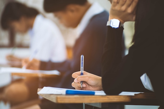 Schließen sie herauf hand der studentenlese- und -schreibensprüfung mit druck im klassenzimmer Premium Fotos