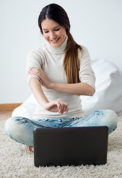 Schöne junge frau arbeitet an ihrem laptop zu hause