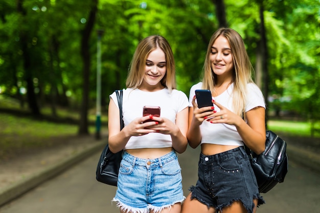 Schone Zwei Frauen Die Handy Im Park Benutzen Freunde Und Sommerkonzept Kostenlose Foto