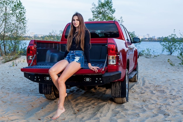 Schönes Sexy Mädchen Mit Langen Haaren In Kurzen Jeans Shorts Und Einem Schwarzen Body Posiert 