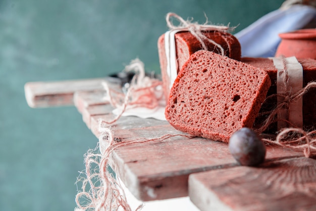 Schwarzbrotscheiben eingewickelt mit weißbuch und pflaumen auf einem holztisch. Kostenlose Fotos
