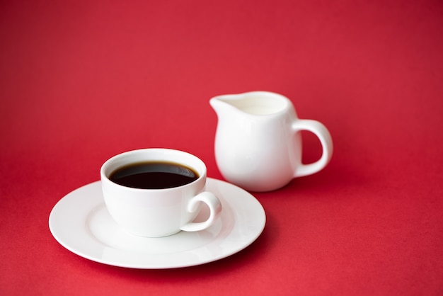 Schwarzer kaffee in einer kleinen weißen kaffeetasse auf einem roten
