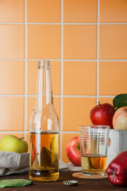 Seitenansicht äpfel in der box mit apfelsaft auf holz und ...