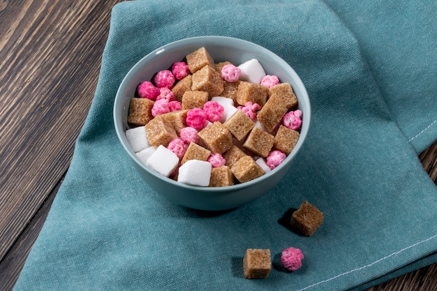 Seitenansicht der braunen zuckerwürfel mit rosa bonbons in einer ...