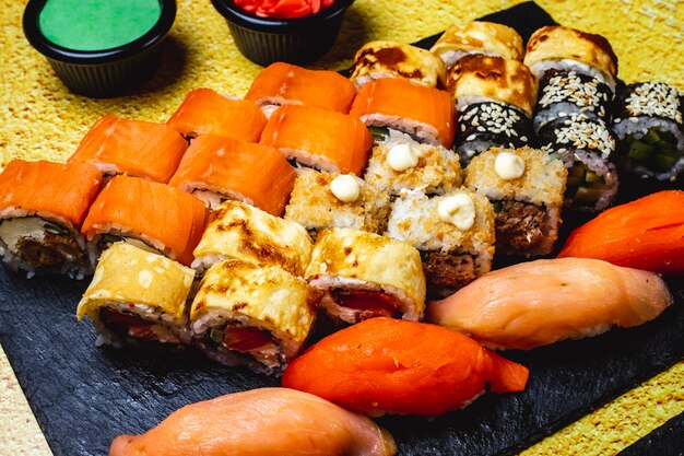 Seitenansicht Sushi Set Eierbrotchen Mit Gurke Und Lachs Philadelphia Mit Frischkase Maki Lachs Nigiri Wasabi Und Ingwer Auf Dem Tisch Kostenlose Foto