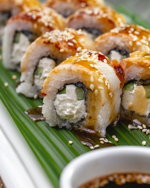 Seitliche ansicht gebackene lachs-sushi-rolle mit nori-frischkäse-gurke ...