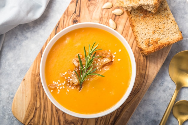 Selbst gemachte autumn butternut squash-kürbiscremesuppe mit brot und samen. ansicht von oben Premium Fotos