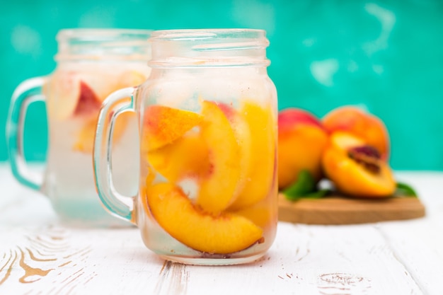 Selbst gemachte gefrorene limonade mit reifen pfirsichen. frischer pfirsicheistee in einem weckglas. Premium Fotos