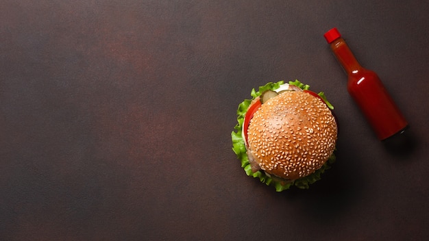 Selbst gemachter hamburger mit bestandteilrindfleisch, tomaten, kopfsalat, käse, zwiebel, gurken und pommes-frites auf rostigem hintergrund Premium Fotos