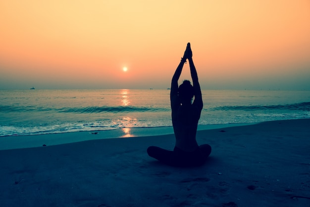 Silhouette Der Frau Die Yoga Auf Einem Strand Kostenlose Foto