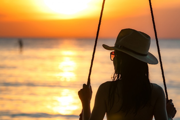 Silhouette Frau Tragen Bikini Und Strohhut Schwingen Die Schaukeln Am Strand In Den Sommerferien Bei Sonnenuntergang Premium Foto