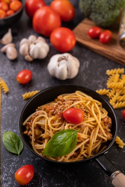 Spaghetti in einer pfanne mit tomaten und basilikum gebraten ...