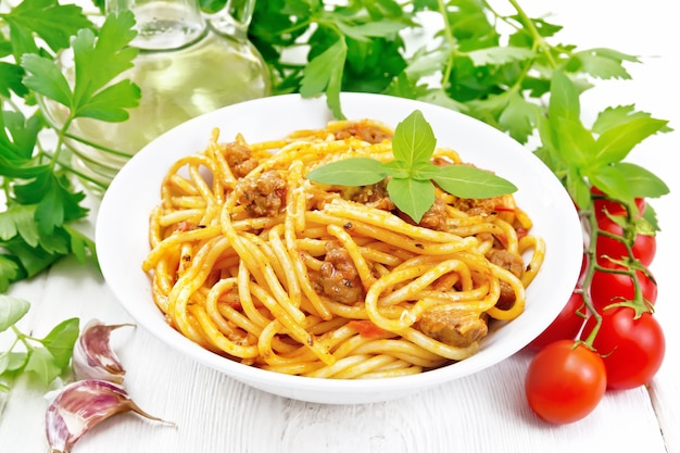 Spaghetti nudeln mit sauce bolognese, basilikum im teller auf holz ...