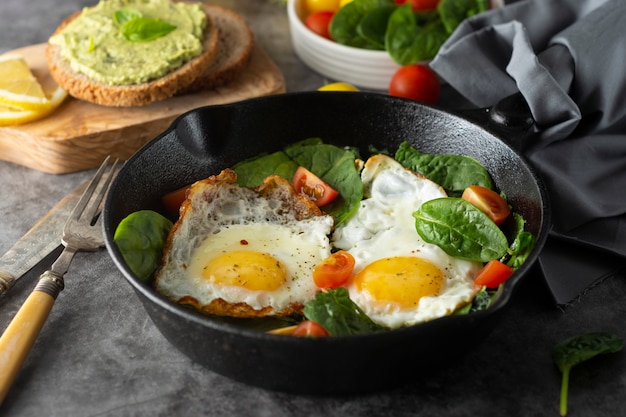 Spiegeleier mit spinat, avocado-toast und frischen tomaten, gesunde ...