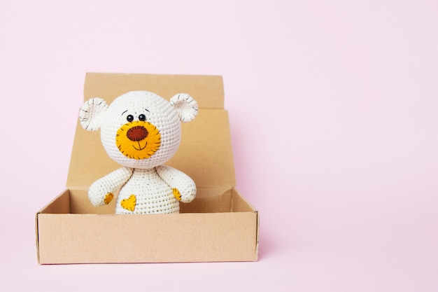 Spielen sie teddybären in einem handwerkskasten, der auf einem rosa hintergrund lokalisiert wird. baby hintergrund. textfreiraum, ansicht von oben Premium Fotos