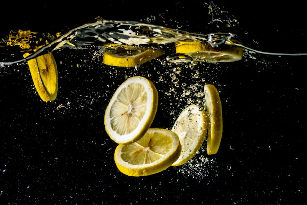 Stillleben Fotografie Aufgenommen Von Zitronenscheiben Die Unter Wasser Fallen Und Einen Grossen Spritzer Machen Kostenlose Foto