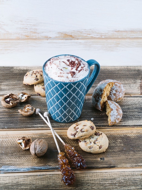 Tasse kaffee mit schlagsahne und plätzchen auf tabelle | Kostenlose Foto