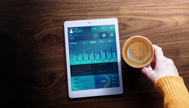 Technologie-, finanz- und geschäftsmarketing im alltagsleben-konzept. frau mit dem heißen kaffee, der diagramme und diagramme sieht, stellen auf digital-tablet dar. ansicht von oben Premium Fotos