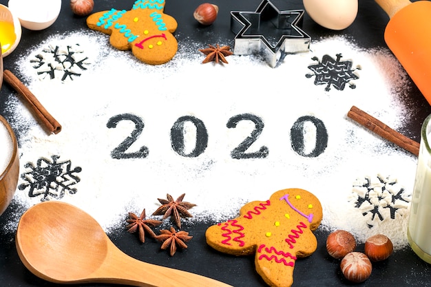 Text 2020 gemacht mit mehl mit dekorationen auf einem schwarzen hintergrund. Premium Fotos
