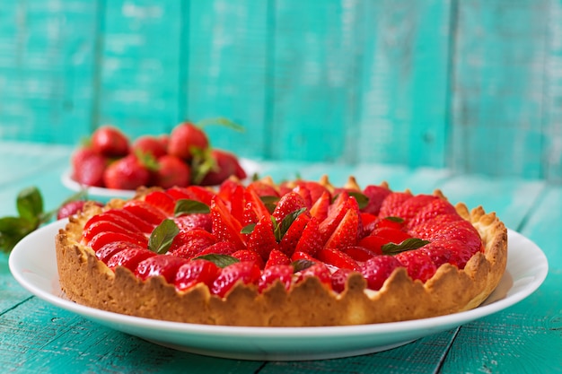 Torte mit erdbeeren und schlagsahne, dekoriert mit minzblättern ...