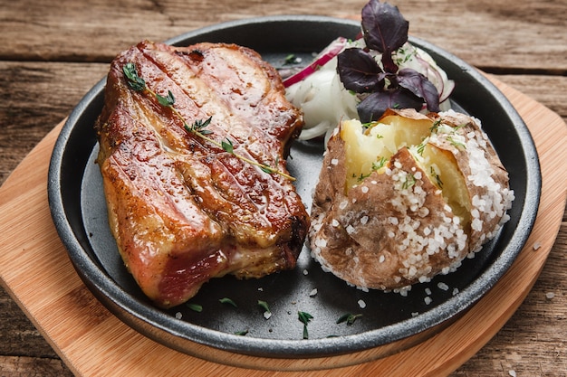 Traditionelles Amerikanisches Essen Kostlicher Gegrillter Rindfleischpfahl Mit Ofenkartoffel Und Zwiebelringen Die Auf Schwarzem Teller Serviert Werden Premium Foto