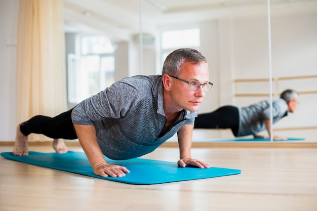 Übende yogapositionen des erwachsenen mannes Kostenlose Fotos