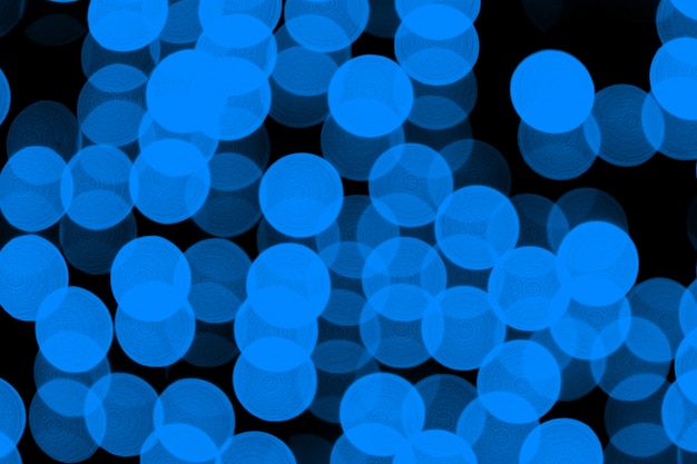 Unfocused abstraktes dunkelblaues bokeh auf schwarzem hintergrund. unscharf gestellt und verschwommen viele runde licht Premium Fotos