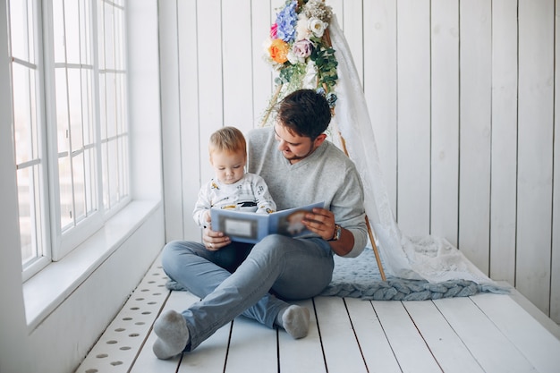 Vater, der zu hause mit kleinem sohn sitzt Kostenlose Foto