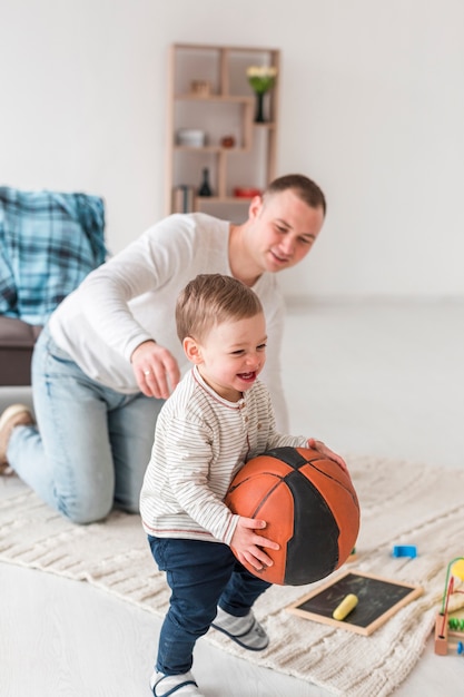 Vater mit smiley-baby zu hause | Kostenlose Foto