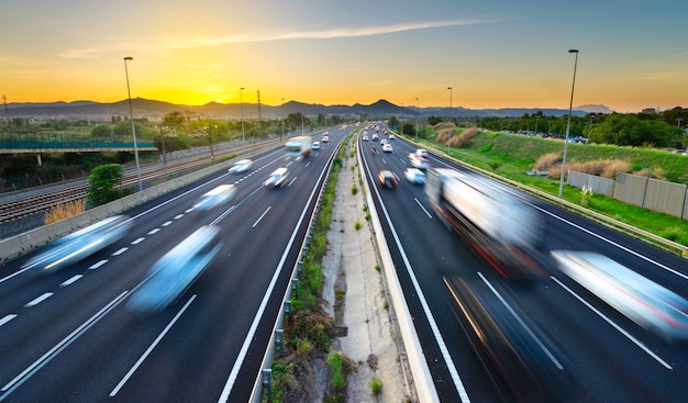 Verkehrsreiche landstraße bei sonnenuntergang, kommende und gehende