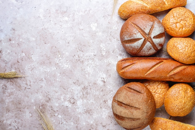 Verschiedene arten von frischem brot als hintergrund draufsicht 