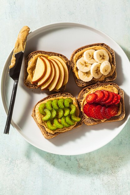 Verschiedene sandwiches mit erdnussbutter und erdbeeren, sellerie ...