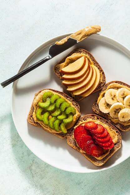 Verschiedene sandwiches mit erdnussbutter und erdbeeren, sellerie ...