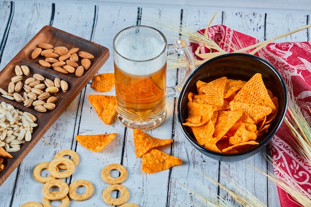 Verschiedene snacks, pommes und ein glas bier auf dem